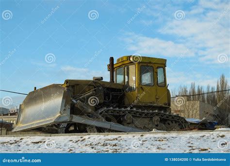 Dirty Yellow Bulldozer On The Winter Road Because Construction Stopped