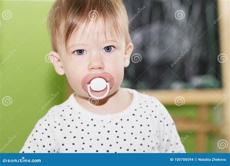 Portrait Of A Beautiful Baby With Pacifier In The Mouth Stock Photo