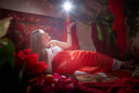 Beautiful Arabian Girl With Candles In Red Room Full Of Rich Fabrics