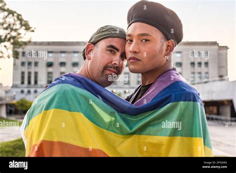 Gay Couple Under Lgbt Rainbow Flag While Looking At Camera Concept Of Pride Pride Month Stock