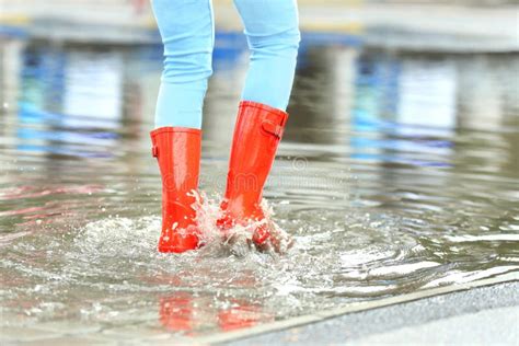 Mujer Con Las Botas De Goma Rojas En El Charco Primer Lluvioso Foto De