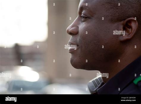 Close Up Profile Portrait Of Uniformed Police Officer Sitting Outside