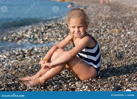 Menina Bonita Que Senta Se Na Praia Foto De Stock Imagem De Exterior