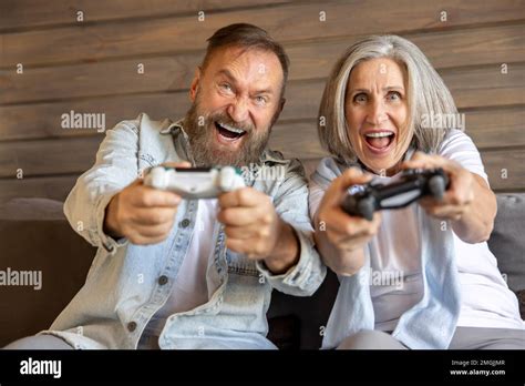 Mature Couple Playing Video Games And Looking Excited Stock Photo Alamy