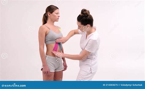 Therapist Is Applying Kinesio Tape To Female Body Physiotherapy And