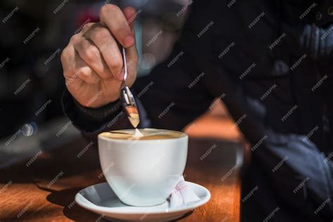 Pessoa Cafe Com Leite - Mão de uma pessoa, mexendo o café com leite com colher na xícara de ...