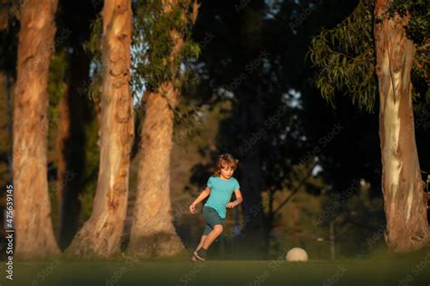 Boy child playing football on football field. Kid playing soccer. Child ...