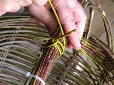 A Person Is Tying Some Kind Of String To A Wicker Basket With Two Hands