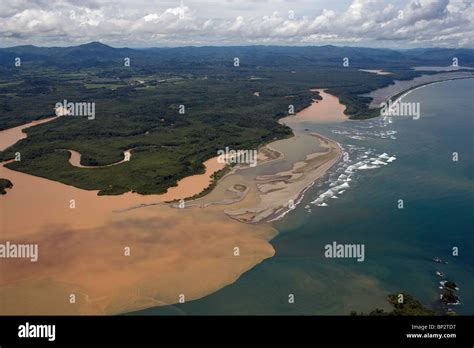 Aerial View Above Sediment Filled Muddy River Flowing Into Pacific