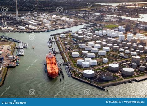 Aerial View Of A Large Orange Oil Tanker Moored At An Oil Storage Silo