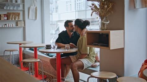 Un couple gay insouciant qui sortent dans un café multiethnique Deux hommes qui s embrassent