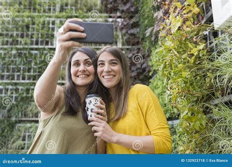 Two Beautiful Women Taking A Selfie With Mobile Phone One Is Holding A