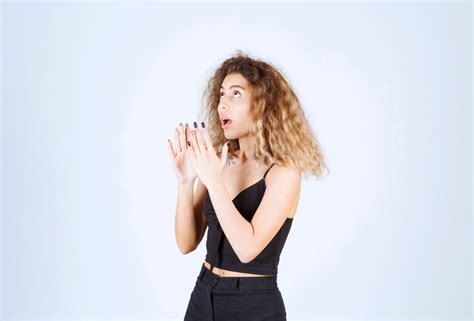 Femme Blonde Pointant Quelque Part Au Dessus Photo Gratuite