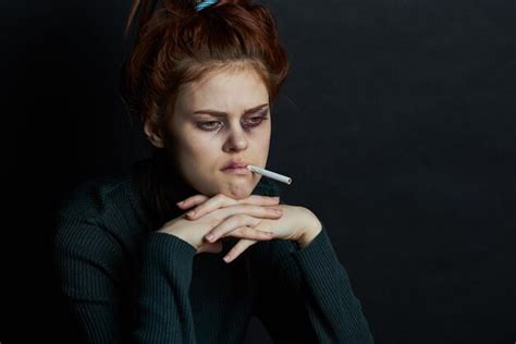 Premium Photo Portrait Of Young Woman Holding Cigarette Against Black