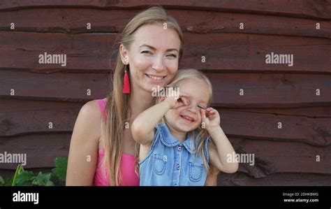 Une jeune mère embrasse et embrasse sa fille blonde Photo Stock Alamy