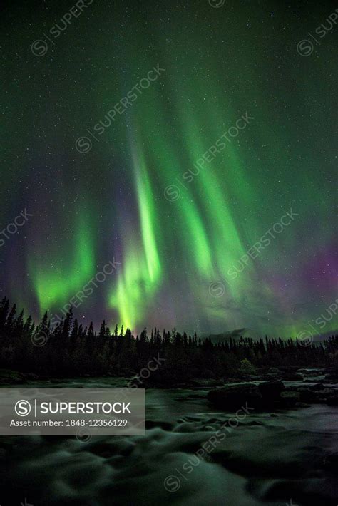 Northern lights or aurora borealis over river, Kvikkjokk, Lapland ...