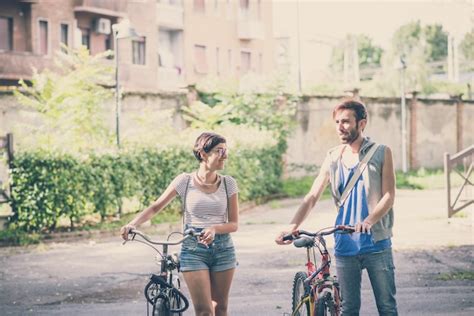 Premium Photo Couple Of Friends Young Man And Woman Riding Bike