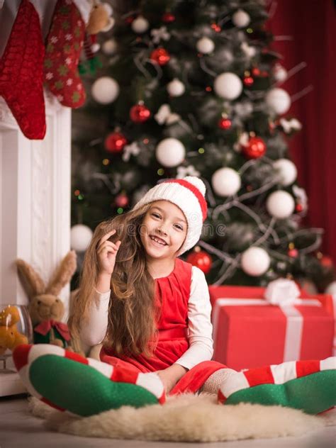 Belle Fille Dans Le Chapeau De Santa Se Trouvant Sur Le Plancher Tir