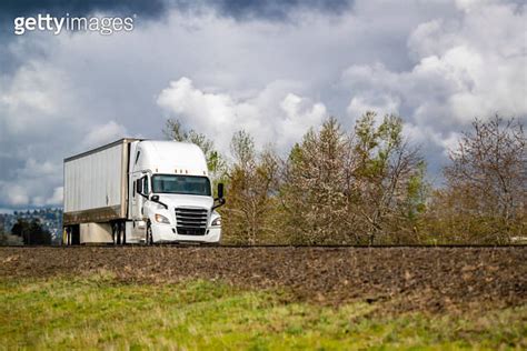 Popular White Big Rig Semi Truck Transporting Cargo In Dry Van Semi