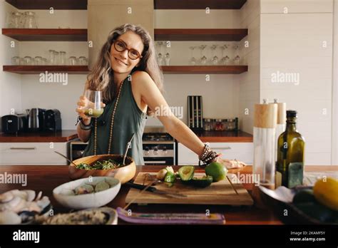 Vegetarian Woman Smiling At The Camera While Holding Some Green Juice Mature Woman Serving