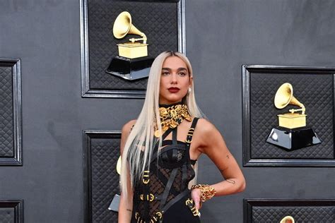 Dua Lipa Debuts Blonde Hair In Black Bondage Dress At Grammys In