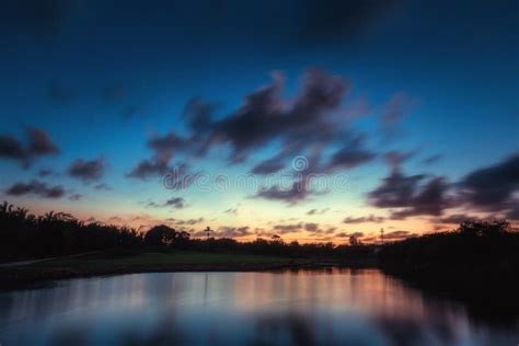 Beautiful Sunset Over The Lake Near The Golf Course In A Tropical