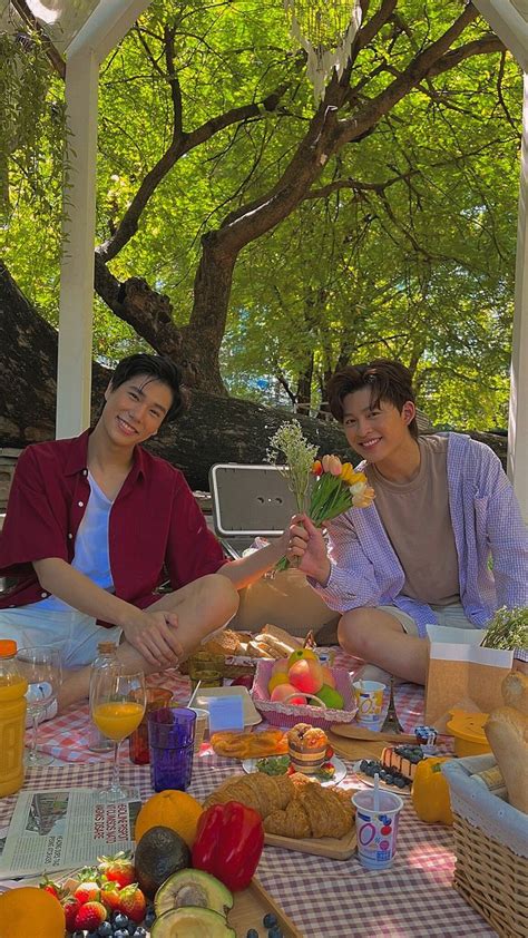 Two People Sitting At A Picnic Table With Food