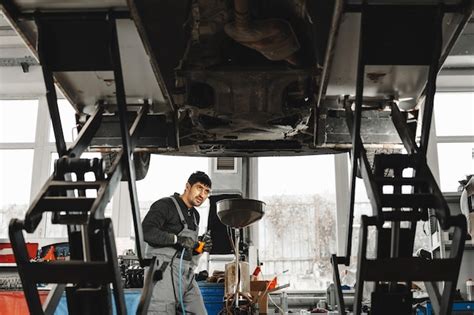 Premium Photo Workman Mechanic Working Under Car In Auto Repair Shop