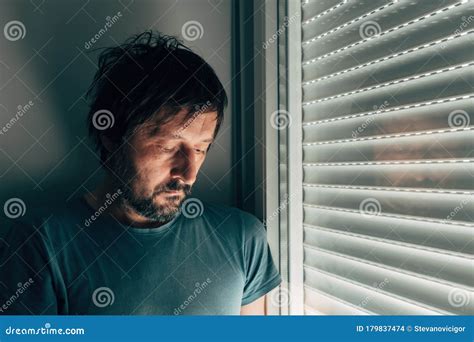 Sulking Man By The Window With Shutters Rolled Down Stock Photo Image