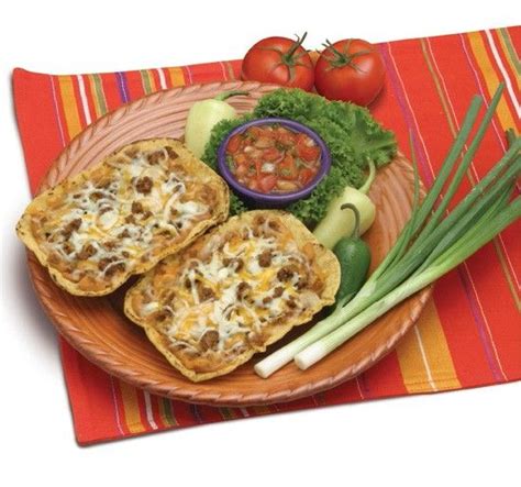 an assortment of food on a plate with chopsticks next to it and tomatoes