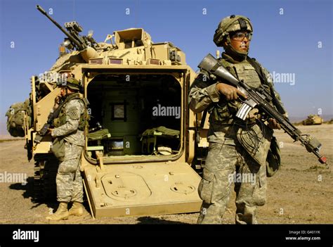 U.S. Army Soldiers provide security with an M2 Bradley Fighting Vehicle ...