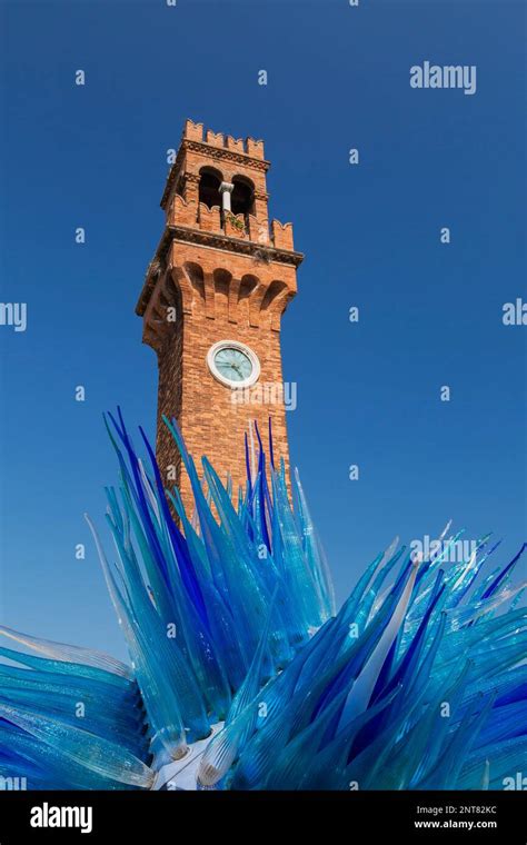 Blue Murano Glass Sculpture And Red Brick Medieval Clock Tower In San Stefano Square Murano