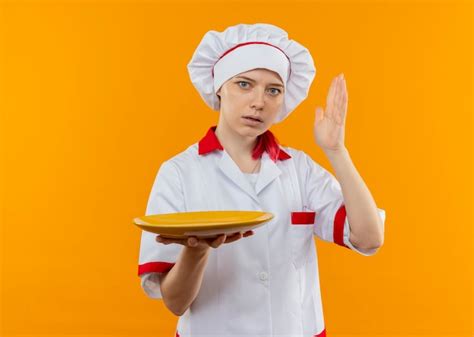 Jeune Femme Blonde Surprise Chef En Uniforme De Chef D Tient La Plaque Et Soul Ve La Main Isol