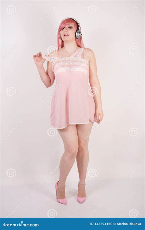 Sexual Plump Redhaired Girl Wearing Pink Lingerie Babydoll Dress With Headphones And Having
