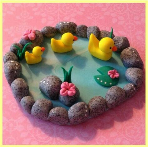 there is a cake decorated with rocks and rubber ducks