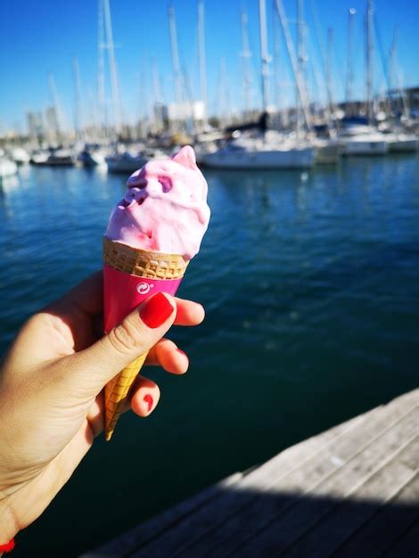 a mão segurando um cone de sorvete na água Foto Premium