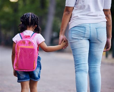 De mãos dadas mãe e filho caminhando para a escola ajudam e cuidam