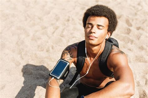 Premium Photo Shirtless Male Athlete Listening To Music Through In Ear Headphones While