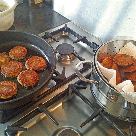 Two Frying Pans Filled With Food Sitting On Top Of A Gas Stovetop