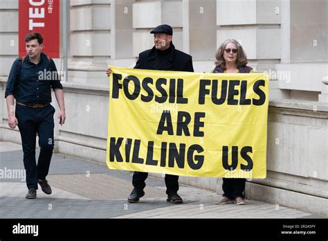 Climate Activists Hold A Banner Saying Fossil Fuels Are Killing Us