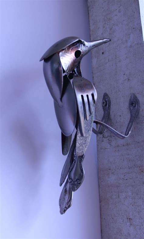 A Metal Bird Is Hanging On The Wall With A Fork In It S Mouth