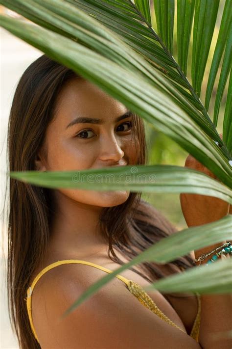 Vertical Close Up Mischief Cute Brunette Woman Hiding Behind Green Palm Tree Leaf Look At