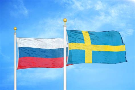 Russia And Sweden Two Flags On Flagpoles And Blue Cloudy Sky Stock