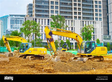 Excavators digging soil at industrial place in Singapore Stock Photo ...