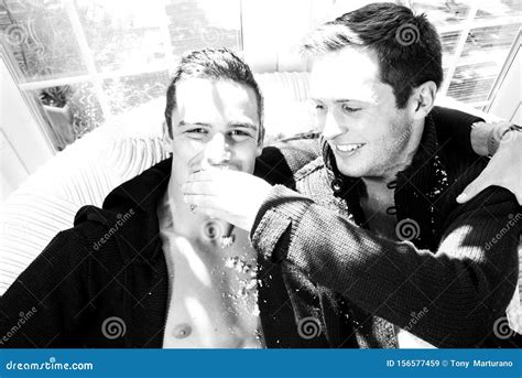 Male Gay Couple Sitting On Armchair Laughing And Feeding Each Other Cake Stock Image Image Of