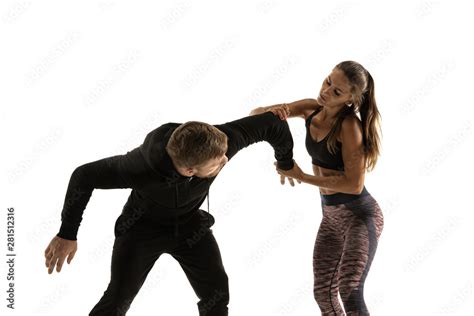 Man In Black Outfit And Athletic Caucasian Woman Fighting On White