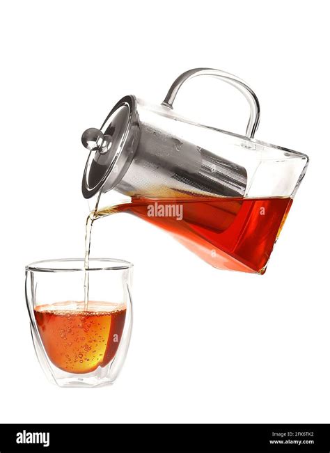 Pouring Of Hot Tea From Teapot Into Glass On White Background Stock Photo Alamy