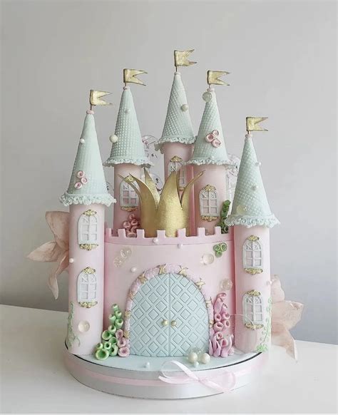 A Pink And Gold Princess Castle Cake With Lots Of Decorations On The