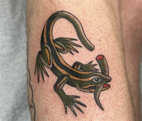 A Lizard Tattoo On The Leg Of A Man