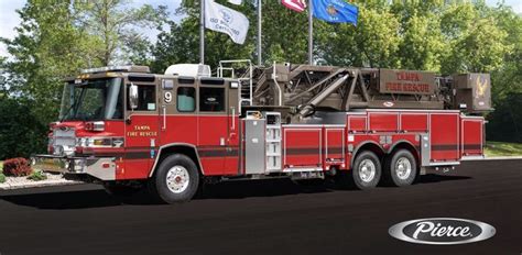 a red fire truck driving down a street next to flags and trees on a ...